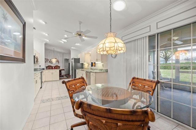 tiled dining area featuring sink, crown molding, vaulted ceiling, and ceiling fan