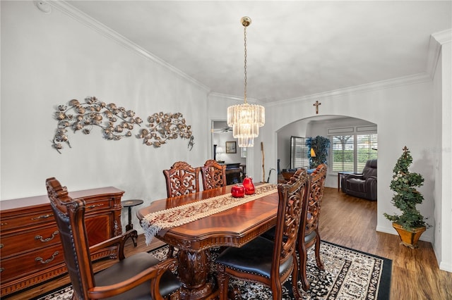 dining area featuring an inviting chandelier, hardwood / wood-style flooring, and ornamental molding