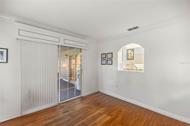 empty room with crown molding and dark wood-type flooring