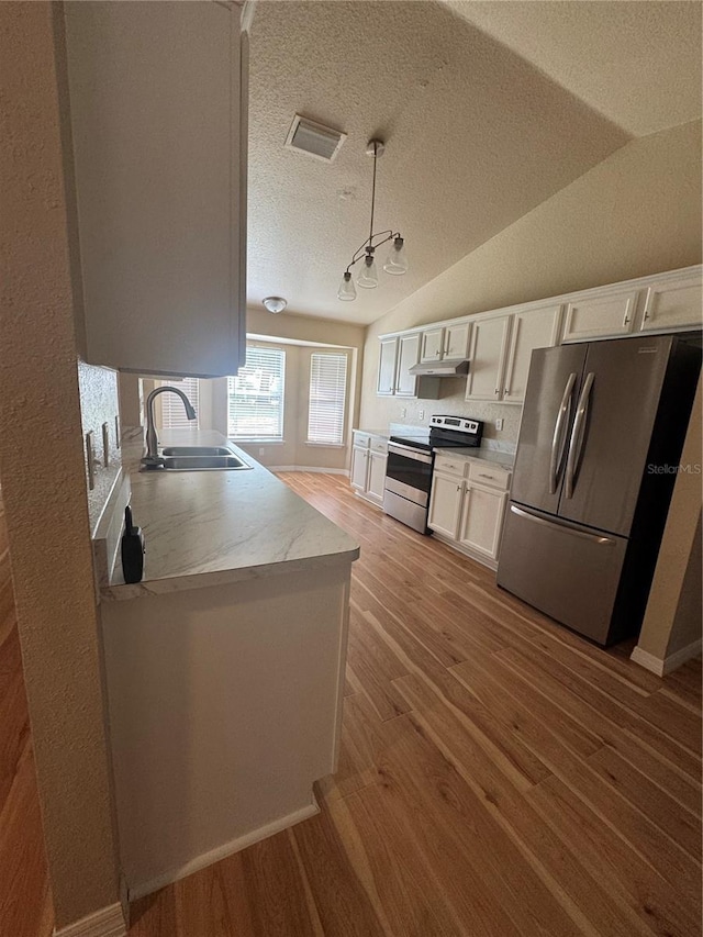 kitchen with sink, decorative light fixtures, appliances with stainless steel finishes, light hardwood / wood-style floors, and white cabinets