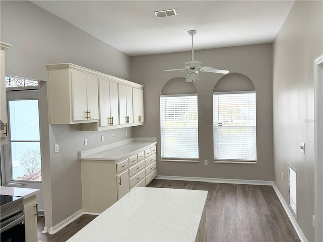 kitchen featuring white cabinetry, dark wood-type flooring, ceiling fan, and range