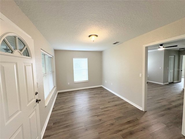 empty room featuring dark hardwood / wood-style floors and a textured ceiling