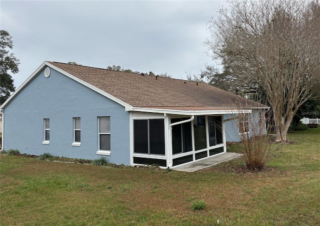 rear view of house with a sunroom and a yard