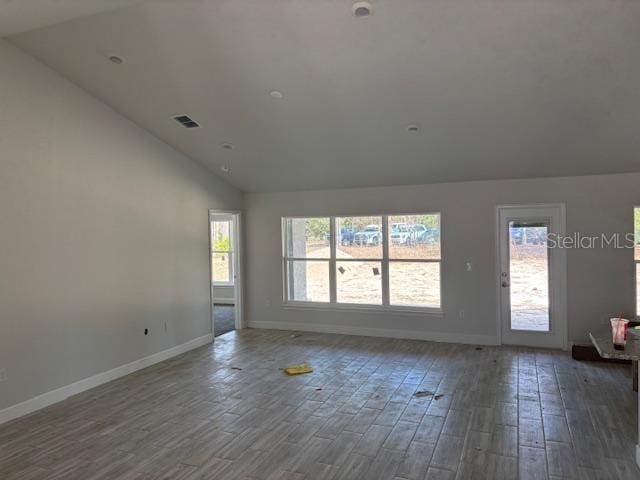 unfurnished room with dark wood-type flooring and lofted ceiling