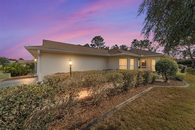 view of side of property with driveway and stucco siding