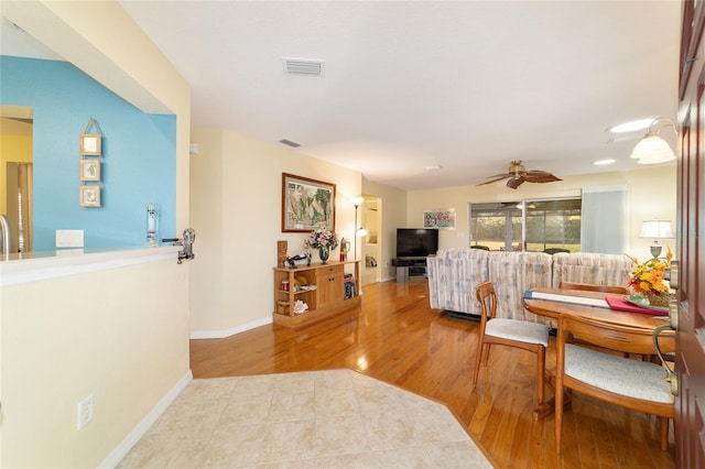 interior space featuring a ceiling fan, baseboards, visible vents, and wood finished floors