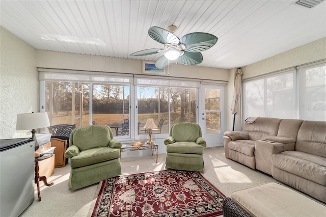 sunroom featuring wood ceiling, ceiling fan, and visible vents