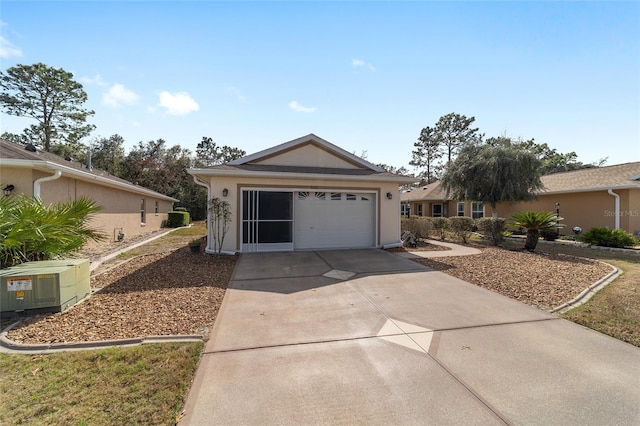 ranch-style home featuring a garage, central AC, driveway, and stucco siding