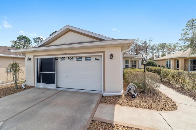 view of front of house with a garage, driveway, and stucco siding