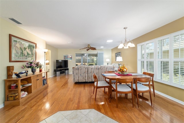 dining room featuring baseboards, light wood finished floors, visible vents, and a healthy amount of sunlight