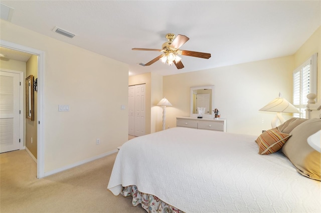 bedroom featuring a closet, visible vents, a ceiling fan, light carpet, and baseboards