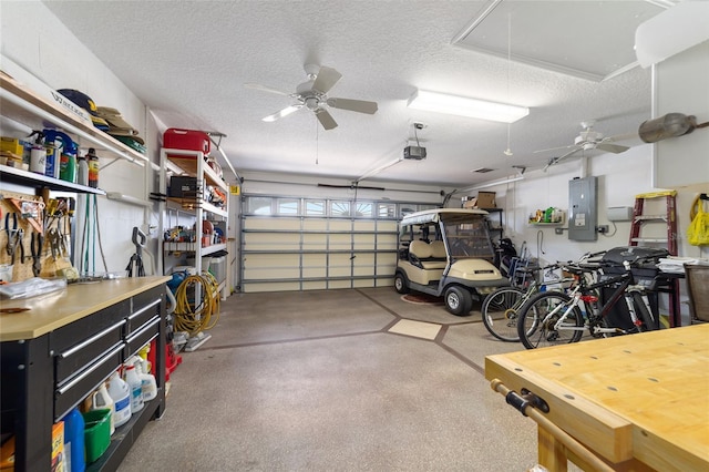 garage featuring electric panel, a ceiling fan, and a garage door opener