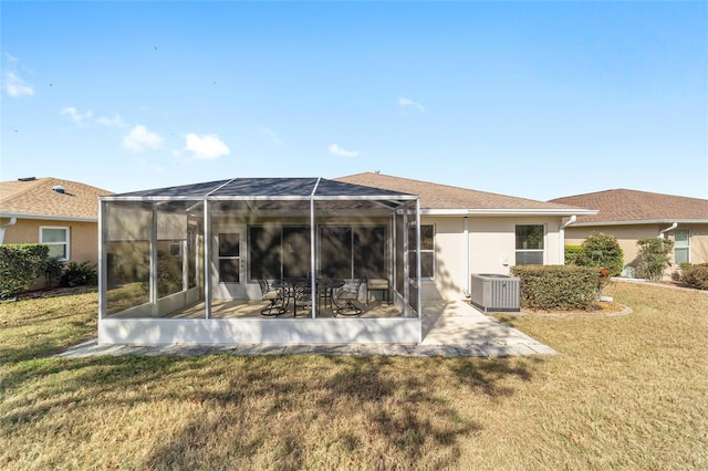 rear view of house with central air condition unit, a yard, a patio, and stucco siding