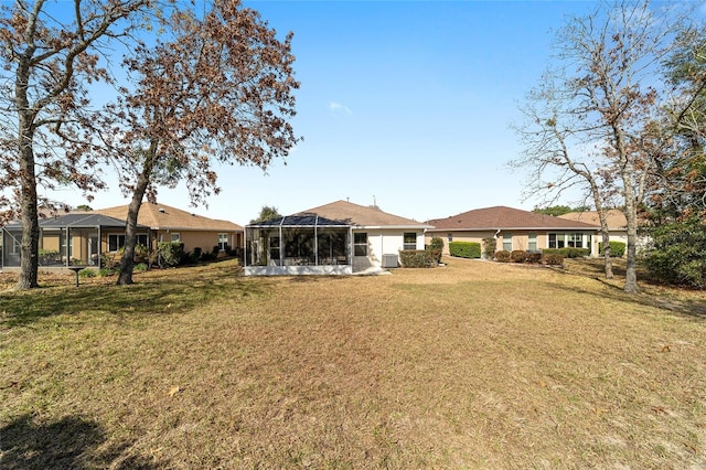 rear view of property featuring a yard and a lanai