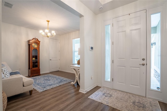 foyer entrance featuring an inviting chandelier and dark hardwood / wood-style floors