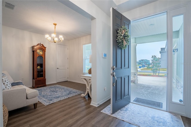 foyer entrance featuring dark hardwood / wood-style flooring and a chandelier