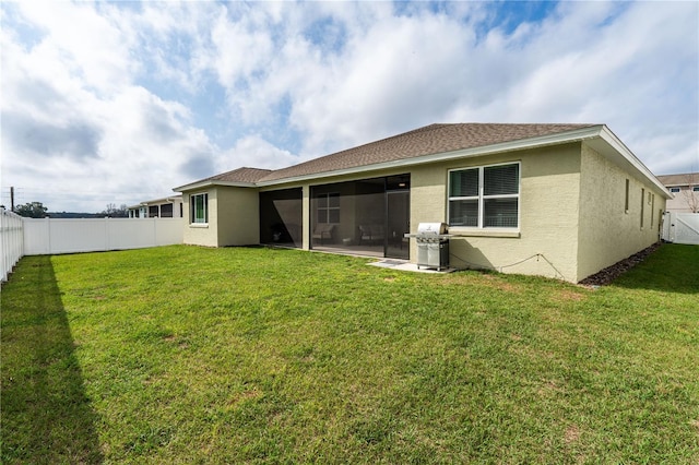 rear view of property featuring a sunroom and a yard