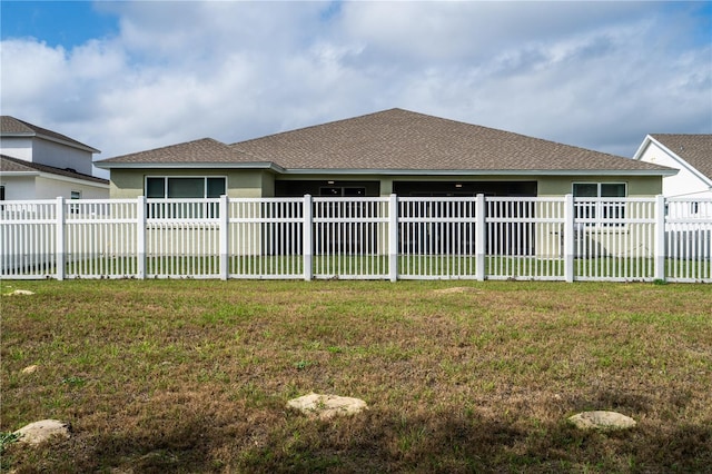 rear view of property featuring a yard