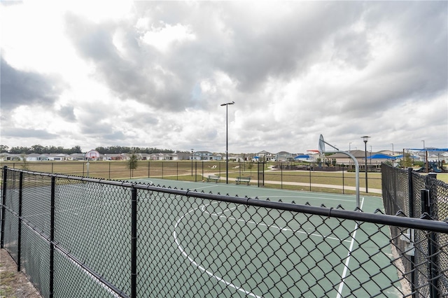 view of tennis court featuring basketball hoop