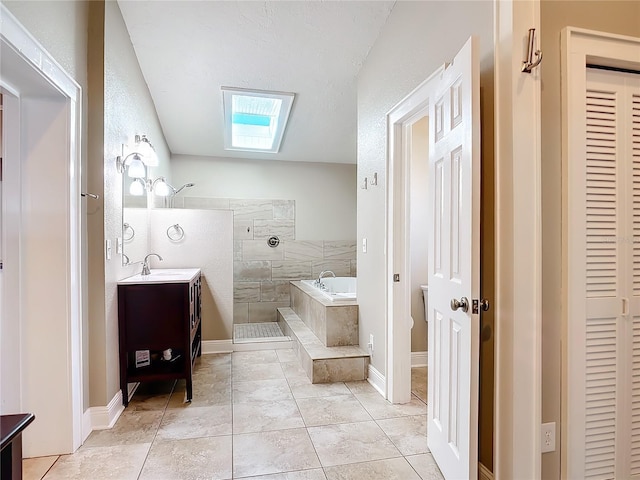 bathroom featuring tile patterned floors, plus walk in shower, a skylight, and vanity