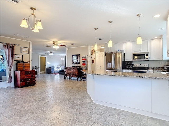 kitchen with appliances with stainless steel finishes, sink, decorative light fixtures, white cabinets, and light stone countertops