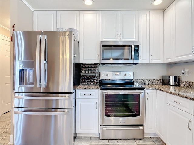 kitchen with white cabinets, stainless steel appliances, and light stone counters