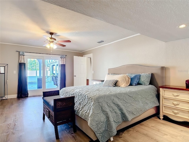 bedroom featuring a textured ceiling, hardwood / wood-style flooring, ceiling fan, and ornamental molding