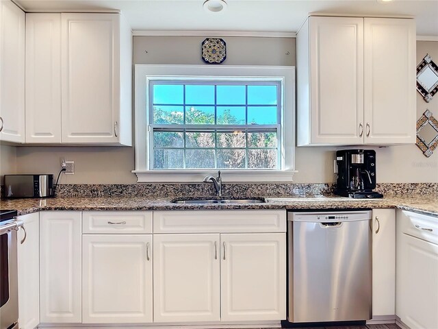 2457 Tamworth Ter, Punta Gorda, FL 33983 - kitchen featuring stainless steel dishwasher, a sink, white cabinets, dark stone counters, and crown molding