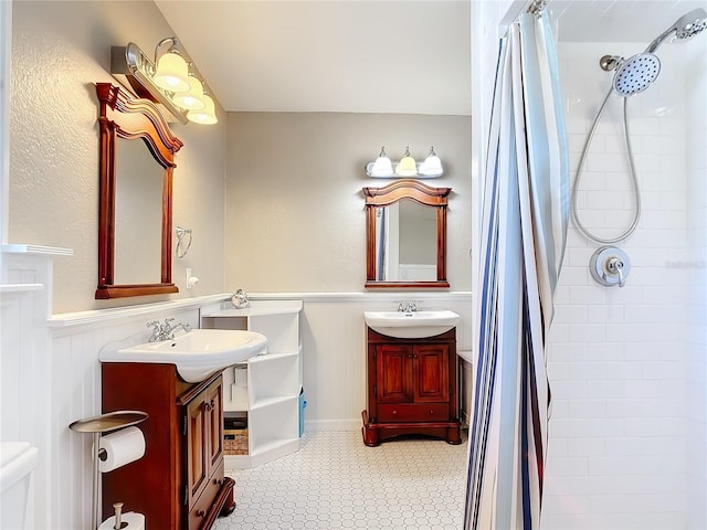 2457 Tamworth Ter, Punta Gorda, FL 33983 - full bathroom featuring two vanities, a wainscoted wall, and a tile shower