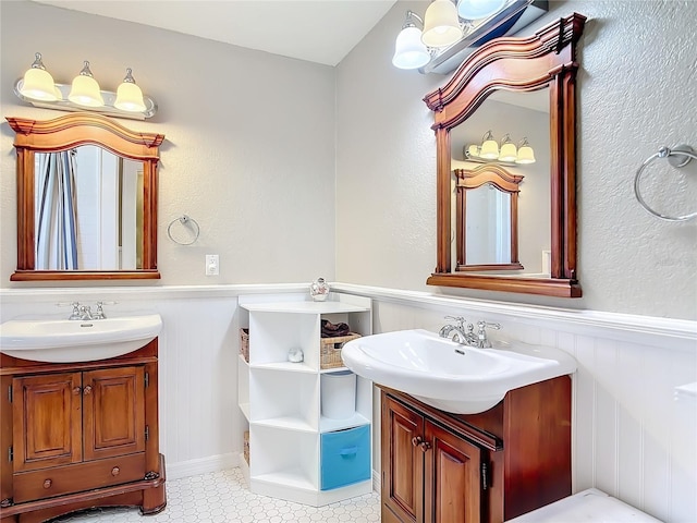 2457 Tamworth Ter, Punta Gorda, FL 33983 - full bath featuring two vanities, a wainscoted wall, and tile patterned floors
