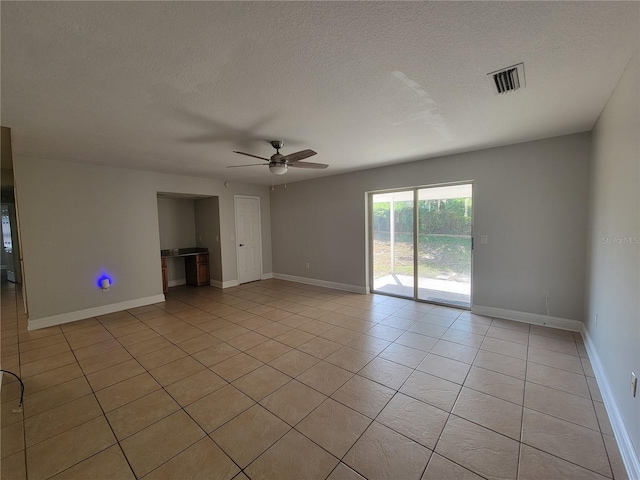 spare room with light tile patterned floors, baseboards, visible vents, ceiling fan, and a textured ceiling