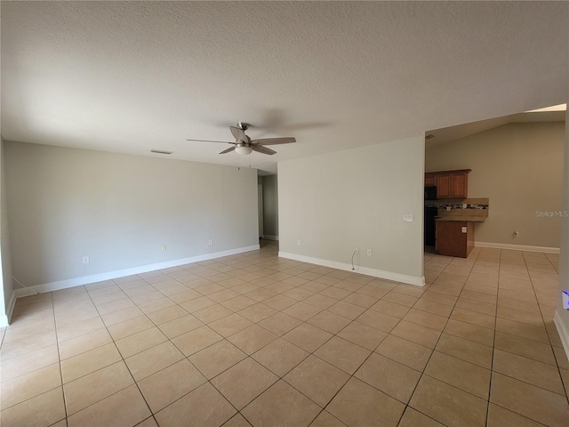 spare room with light tile patterned floors, a ceiling fan, baseboards, visible vents, and a textured ceiling