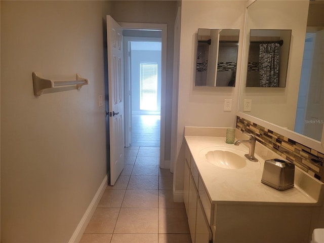 bathroom with vanity, baseboards, tasteful backsplash, and tile patterned flooring