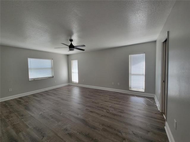 unfurnished room with dark wood-style floors, ceiling fan, a textured ceiling, and baseboards