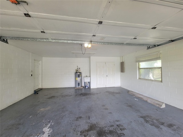 garage featuring concrete block wall, electric panel, a garage door opener, and water heater