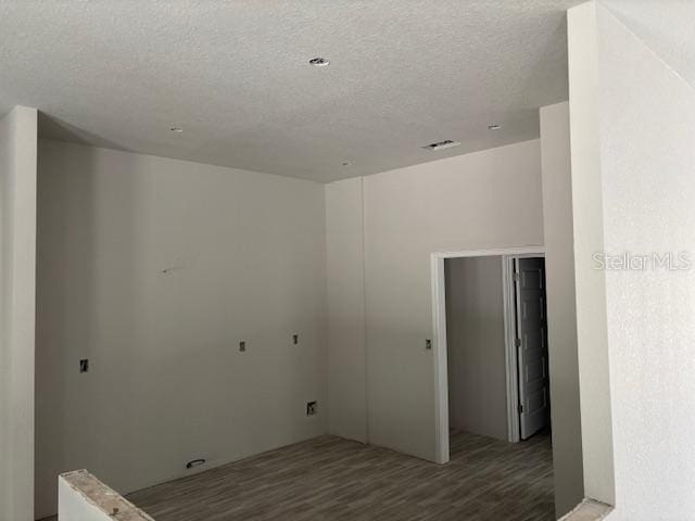 laundry room with hardwood / wood-style floors and a textured ceiling