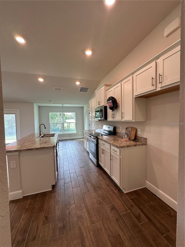 kitchen with sink, light stone countertops, white cabinets, and appliances with stainless steel finishes