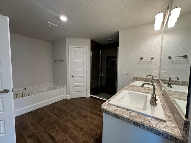 bathroom featuring vanity, plus walk in shower, and a textured ceiling