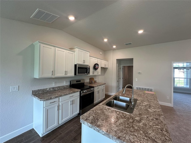 kitchen featuring lofted ceiling, sink, appliances with stainless steel finishes, white cabinetry, and a kitchen island with sink