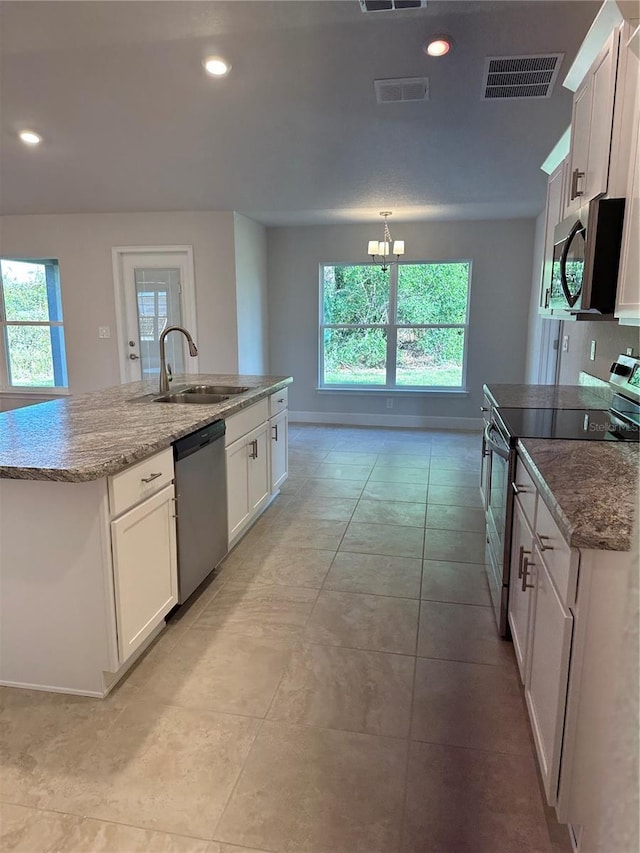 kitchen featuring appliances with stainless steel finishes, sink, an island with sink, and white cabinets