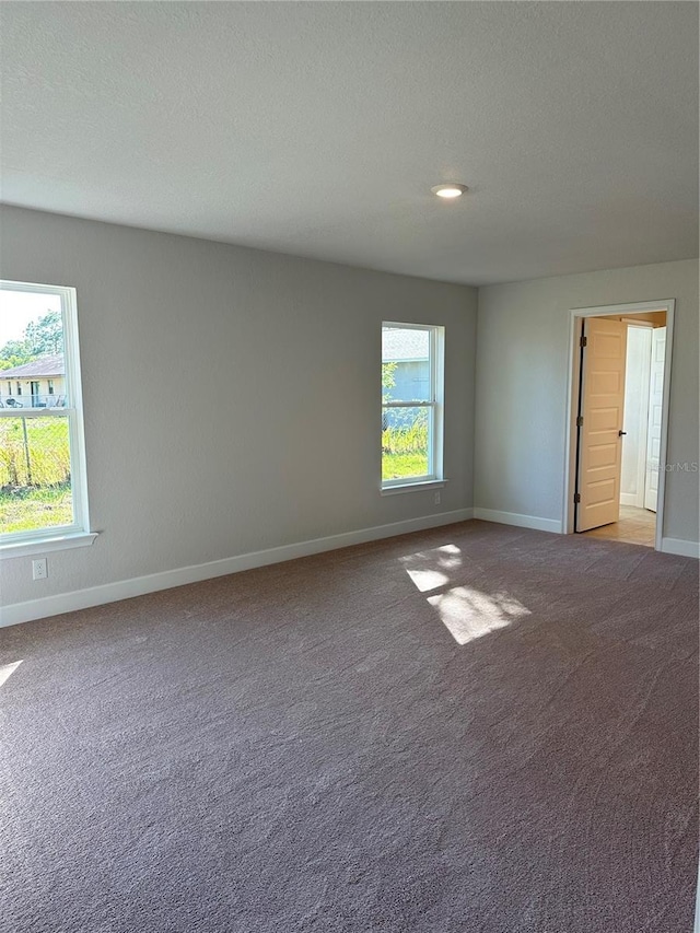 carpeted spare room with a textured ceiling