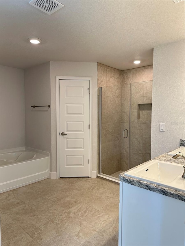 bathroom featuring vanity, plus walk in shower, and a textured ceiling