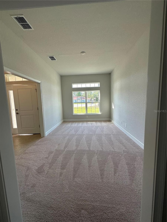 carpeted spare room featuring a textured ceiling