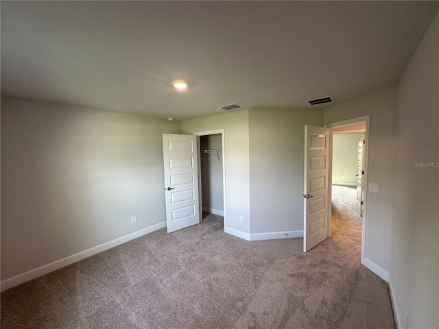 unfurnished bedroom featuring a closet and light carpet