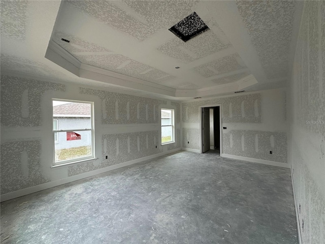 unfurnished room featuring coffered ceiling, ornamental molding, a tray ceiling, and a textured ceiling