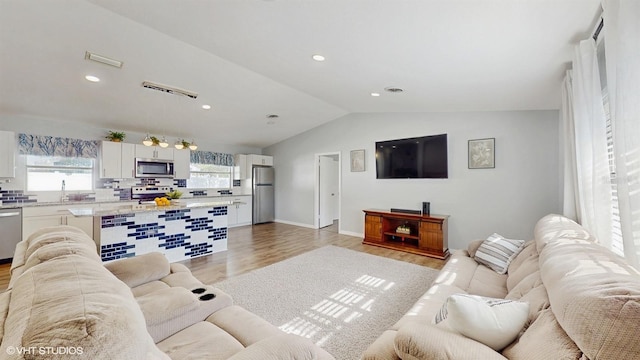 living room featuring lofted ceiling and light wood-type flooring