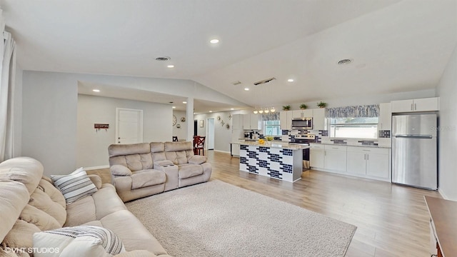 living room with lofted ceiling and light wood-type flooring