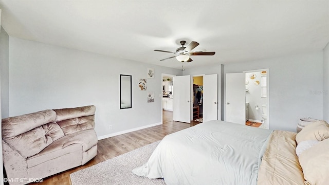 bedroom with ceiling fan, hardwood / wood-style floors, ensuite bathroom, a walk in closet, and a closet