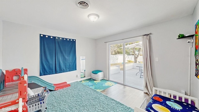 bedroom with wood-type flooring and access to outside