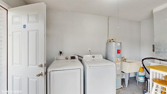 laundry area with independent washer and dryer, water heater, and a textured ceiling